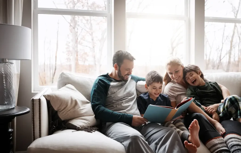 Family home using a recuperator in 2026, family sitting on the couch enjoying the warmth of the house